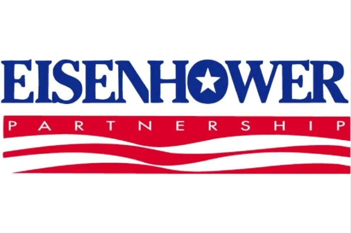 Logo with the word Eisenhower in blue, with a star inside the O. Below, a red banner with Partnership in white letters, over red and white wavy lines. The background is white.