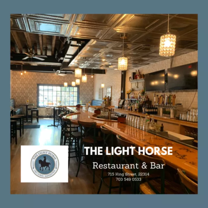 A cozy bar and restaurant with wooden tables, bar stools, hanging pendant lights, and a large TV behind the bar. The Light Horse Restaurant & Bar and contact info appear in white text. The Light Horse logo is in the lower left corner.