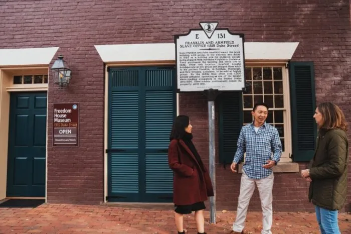 Red brick historic building with white trim and entrance doors on street level
