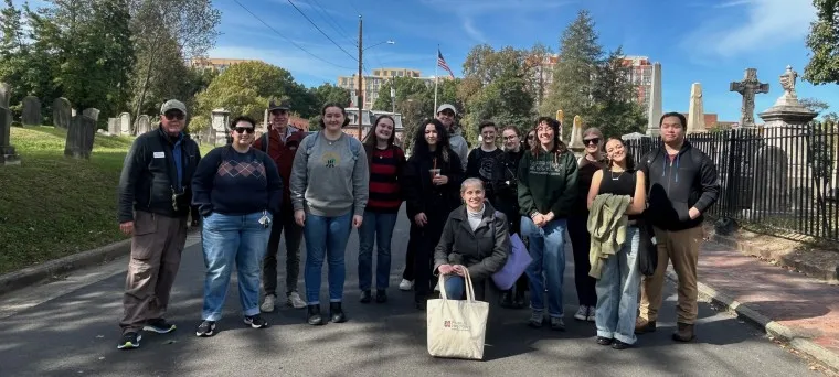 A group of people posing for a photo during the Gravestone Stories walking tour.