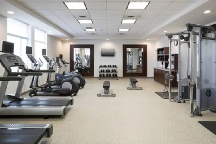 Fitness center with treadmills, ellipticals, and a weight machine.