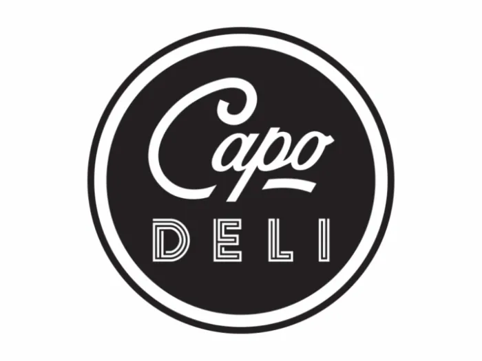 A black and white circular logo with the words Capo DELI in stylized fonts; Capo is in cursive and DELI is in block letters, all centered inside the circle.