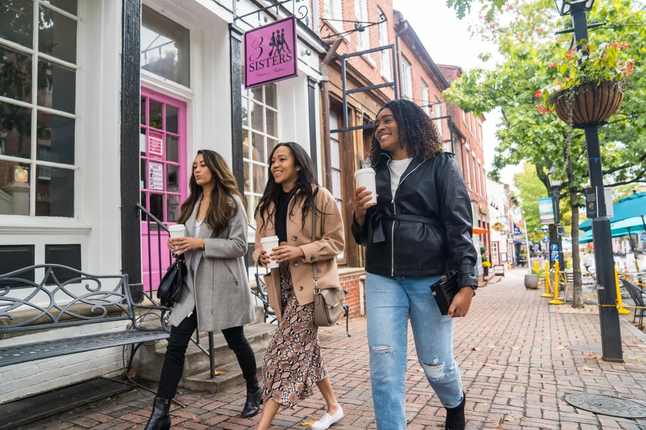 Three women smile while shopping during the holiday season in Old Town Alexandria.