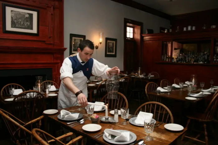 Historic tavern dining room with period furnishings and warm lighting