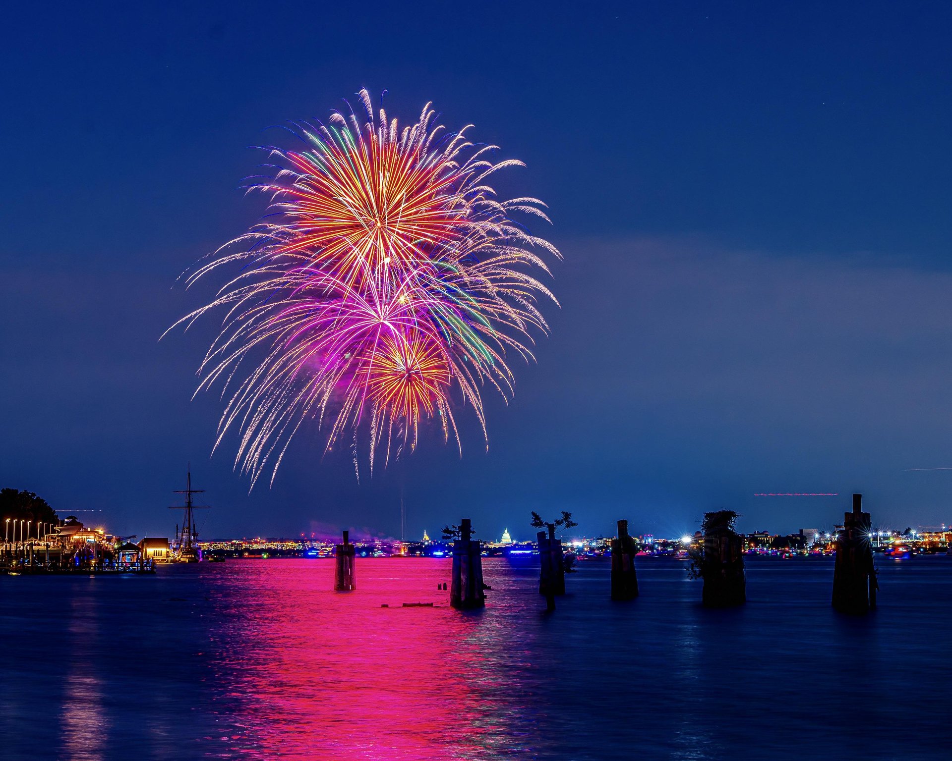 Fireworks lighting up the Potomac River during a nighttime celebration in Alexandria.