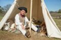 Uniformed soldiers and period tents at Revolutionary War military encampment reenactment