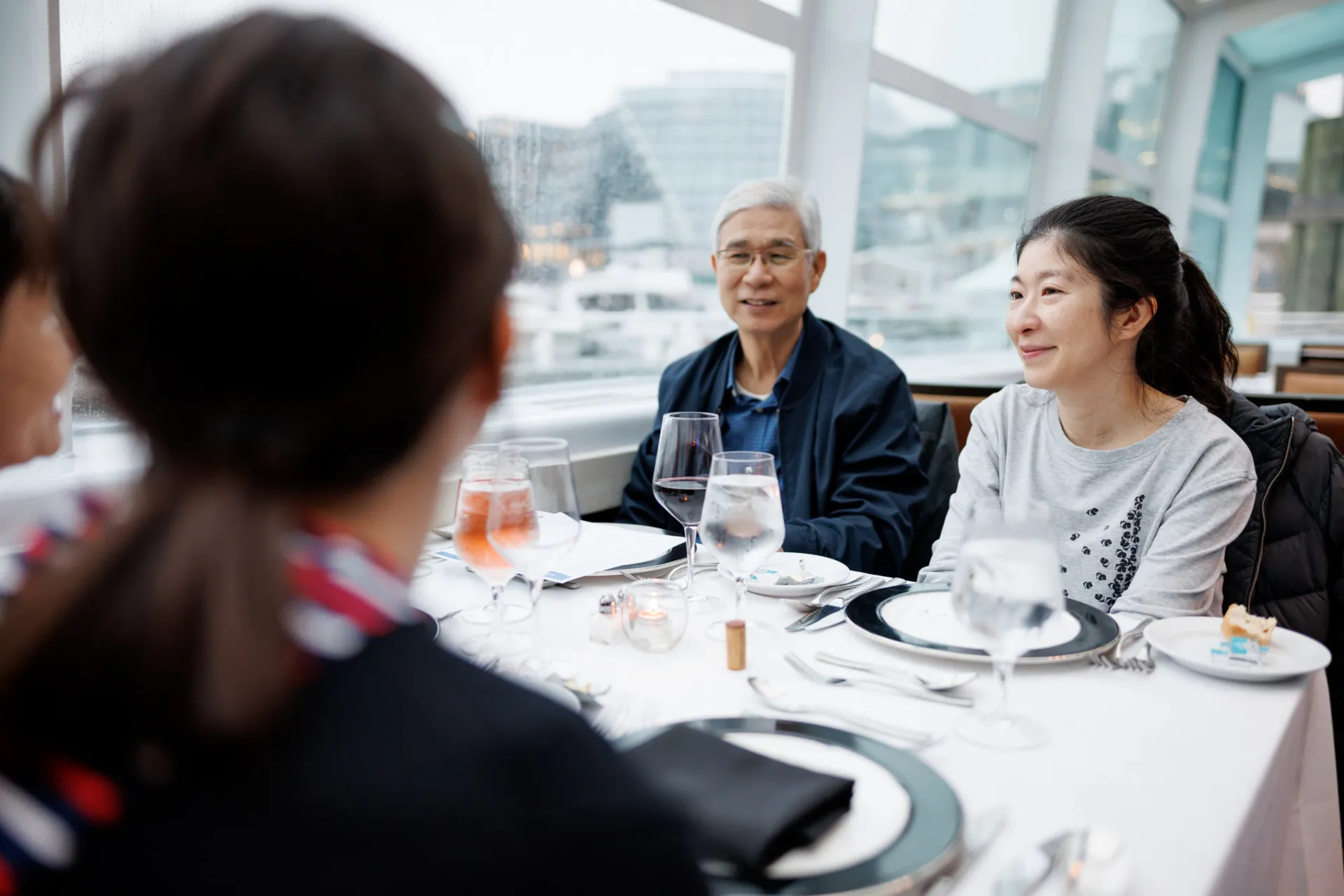 An older man and a younger woman smiling at a dining table during a City Cruises boat trip.