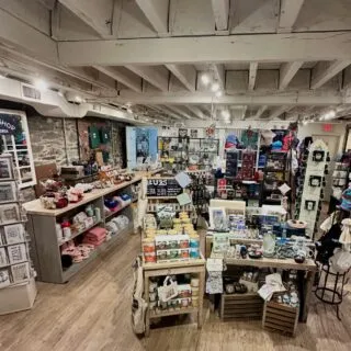 The Old Town Shop's interior features colorful displays of gifts, souvenirs and more. There are clothing items, accessories, snacks, decor and more.