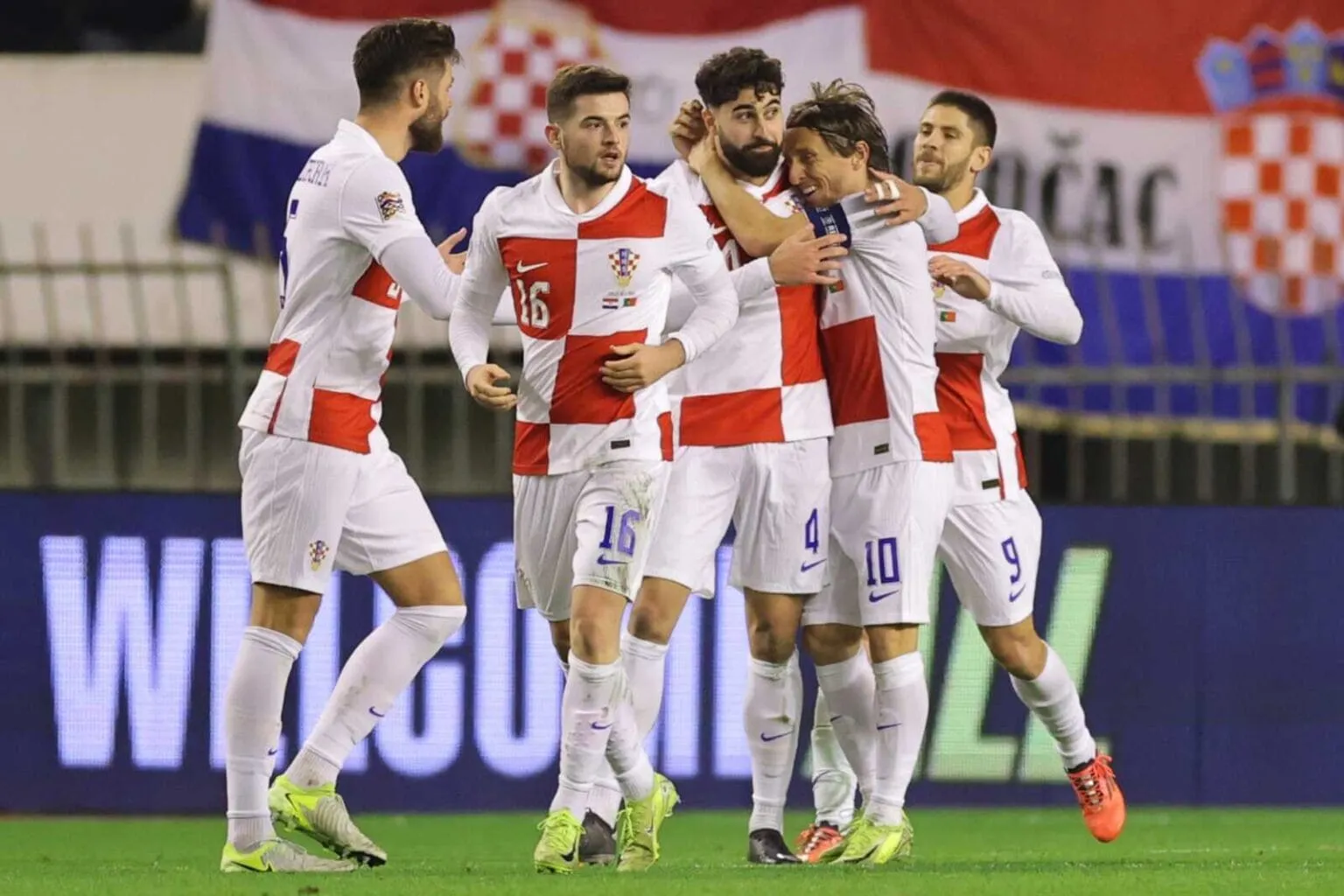 Croatia national football team players, including Luka Modrić, celebrating a goal on the field.