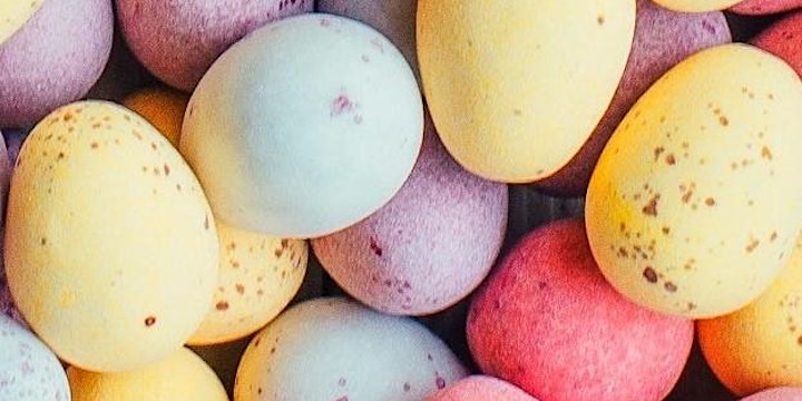 Close-up of colorful, speckled pastel Easter eggs in shades of yellow, blue, and pink.