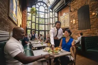 Waiter serving a couple at Josephine Brasserie & Bar in Alexandria.