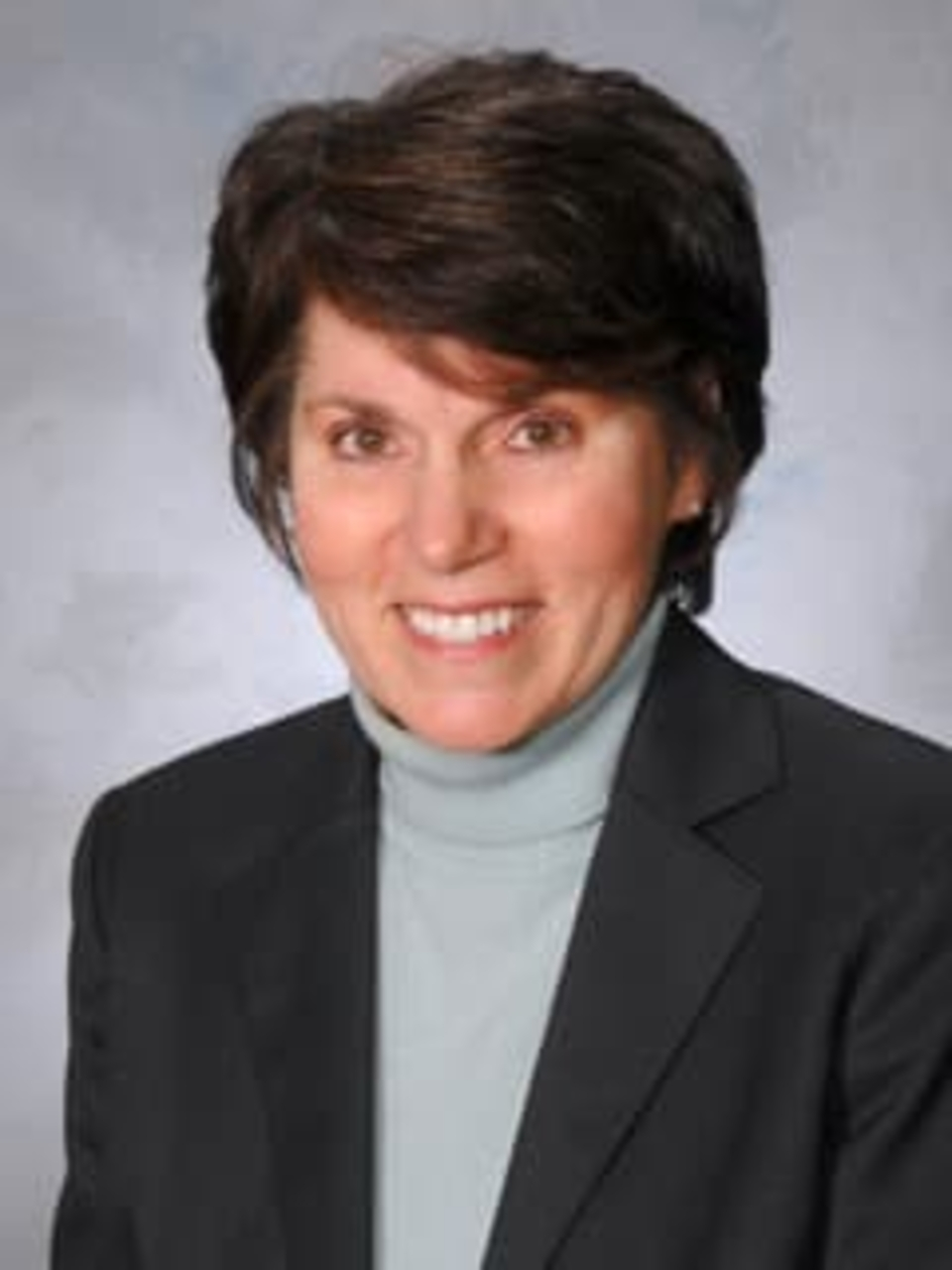 Headshot of Lisa Maiale-Howell smiling, wearing a dark blazer over a light blue top.