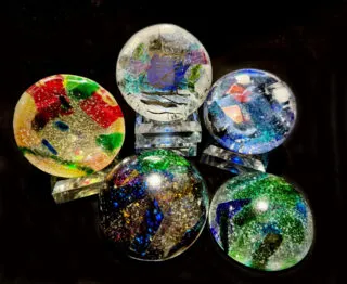 Participants creating handmade glass paperweights at a crafting workshop table