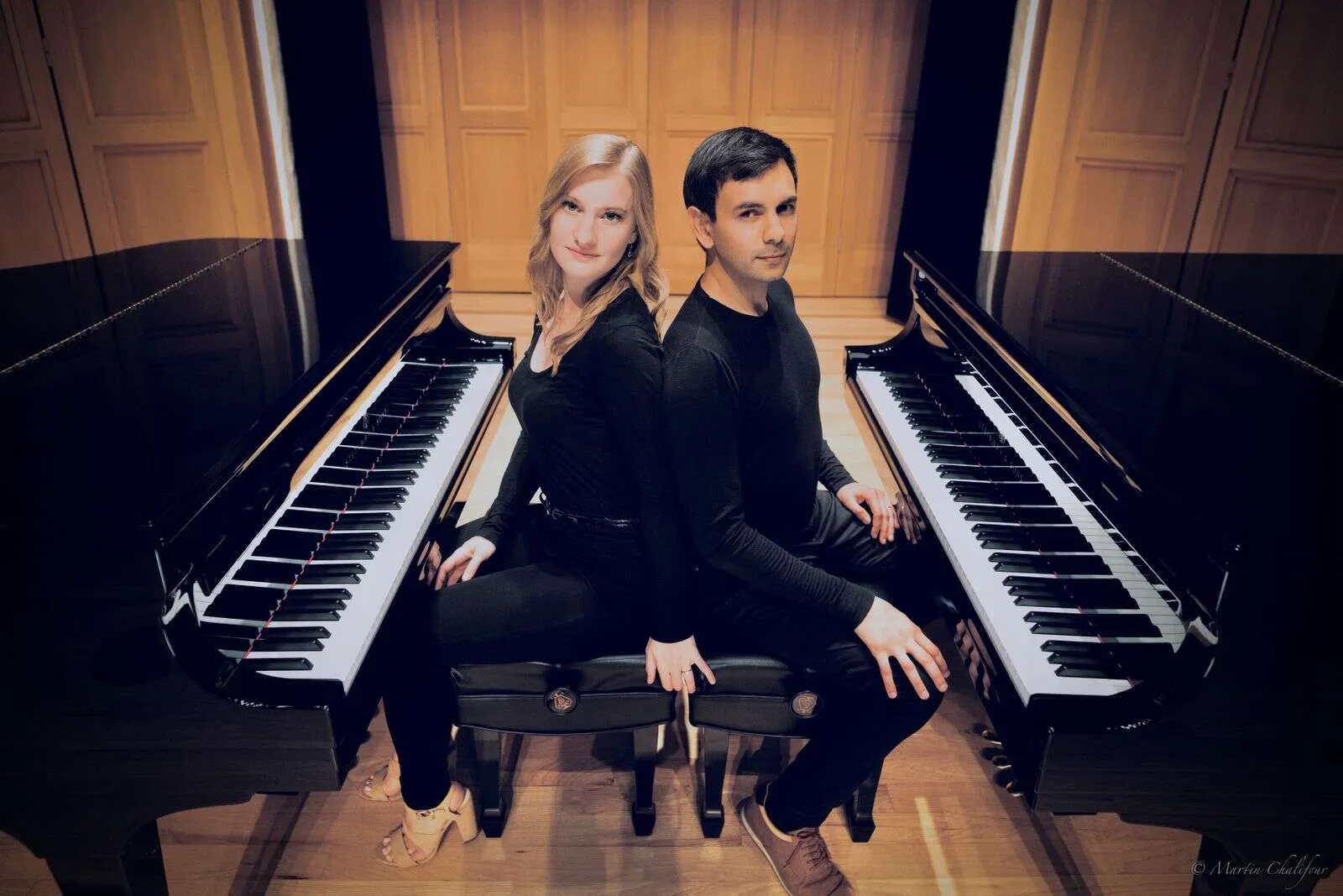 Pianists Vijay Venkatesh and Eva Schaumkell sitting back-to-back at two grand pianos.
