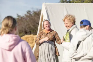 A woman in colonial attire speaking to visitors at George Washington's Mount Vernon.
