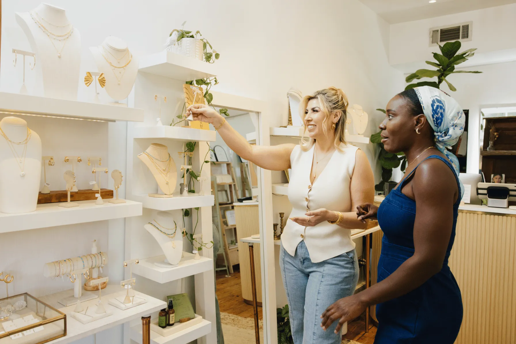 Two women browse shelves of jewelry at She's Unique boutique.