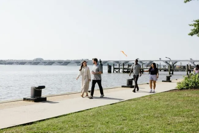 Several visitors stroll along the Potomac River in Old Town Alexandria, VA.