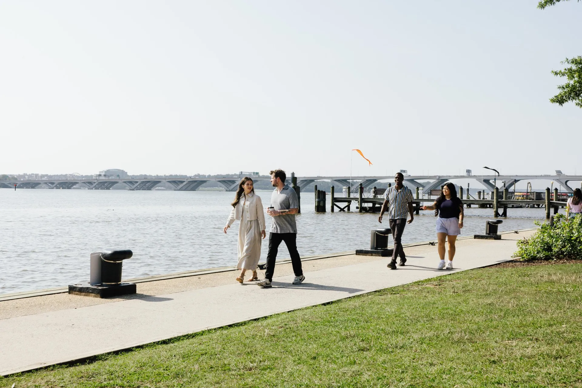 Several visitors stroll along the Potomac River in Old Town Alexandria, VA.