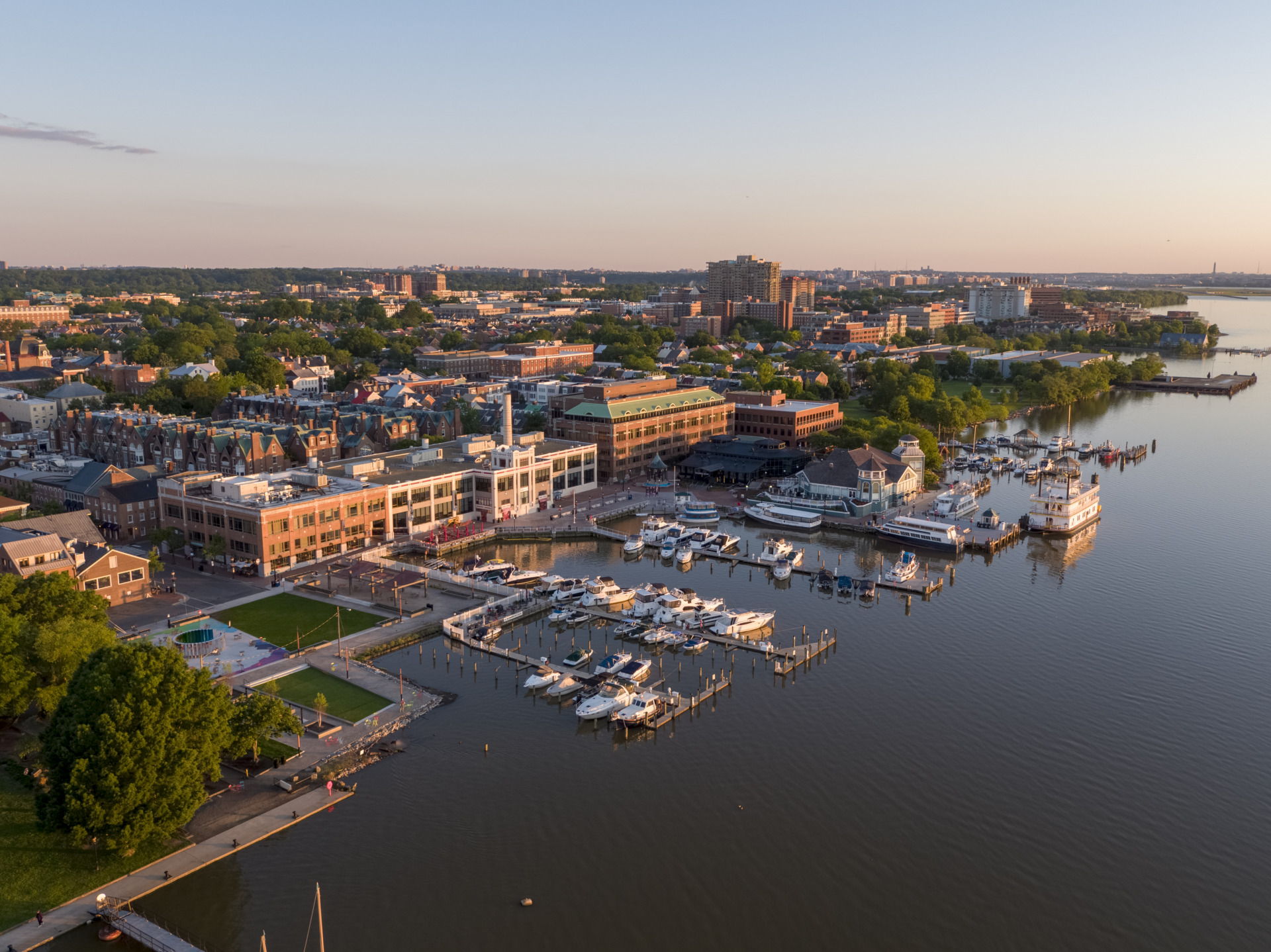An aerial view of the historic Old Town Alexandria waterfront and marina at sunset.