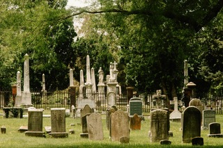 Historic gravestones and markers in the grass at Wilkes Street Cemetery Complex.