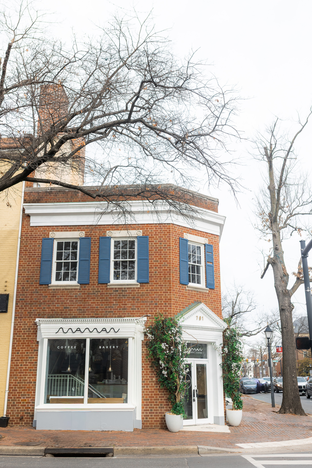 Exterior view of the historic brick building housing Maman café in Old Town Alexandria.