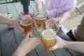 Customers clinking glasses together in a toast at the Beer Garden at Mount Vernon Inn Restaurant.