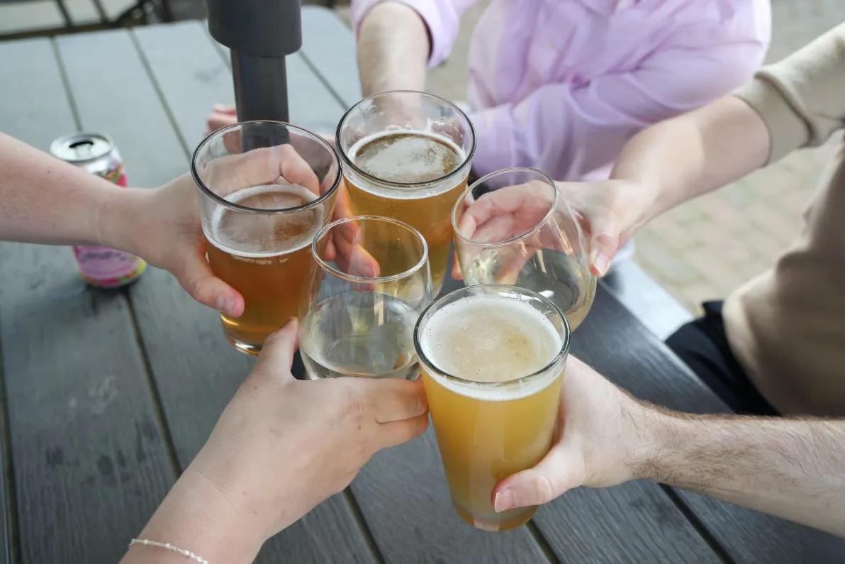 Customers clinking glasses together in a toast at the Beer Garden at Mount Vernon Inn Restaurant.