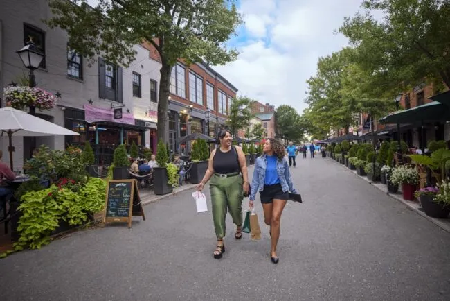 Two women walk down King Street in Old Town Alexandria.