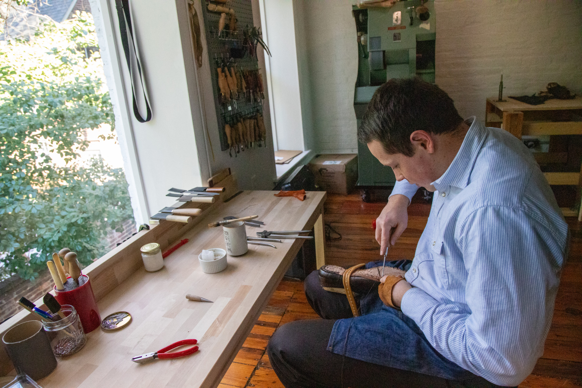 Drew working on attaching the sole of a shoe inside his shoemaking studio at Old House Provisions.
