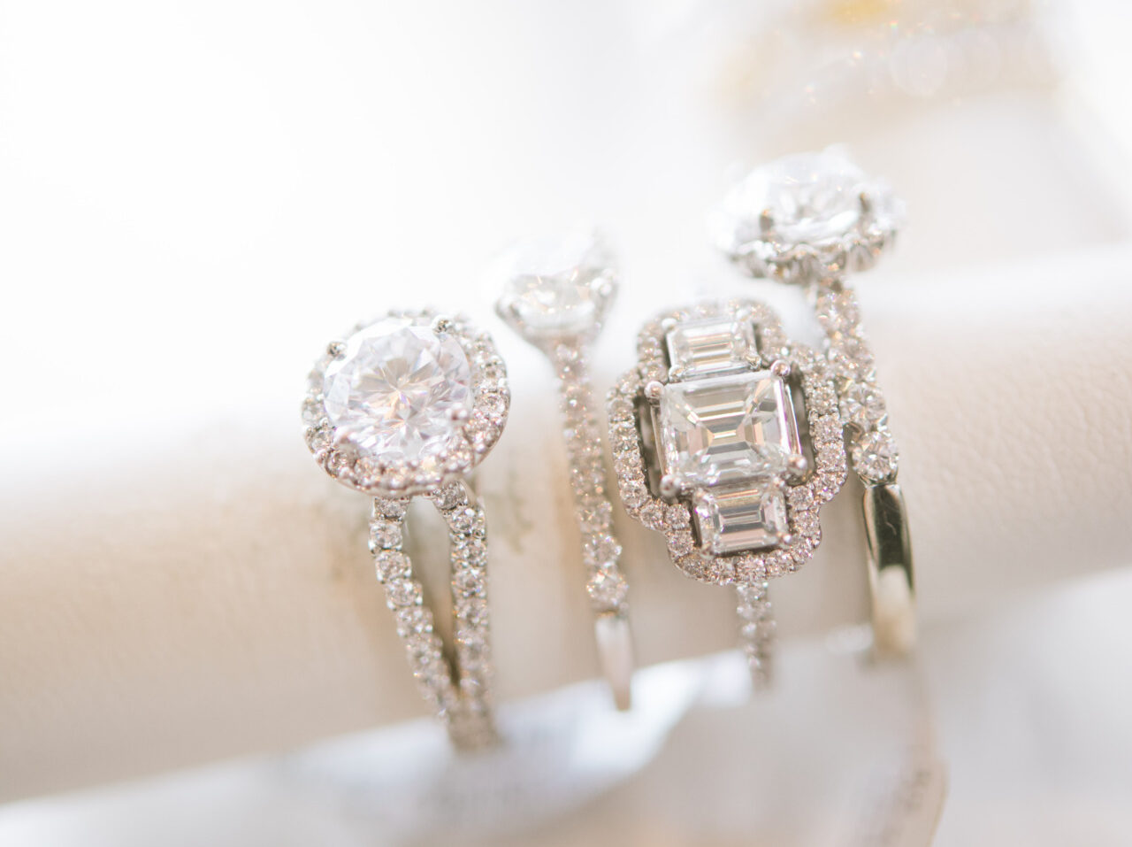 An up-close image of luxury diamond rings displayed on a stand, featuring diamond details and finely cut jewels. 