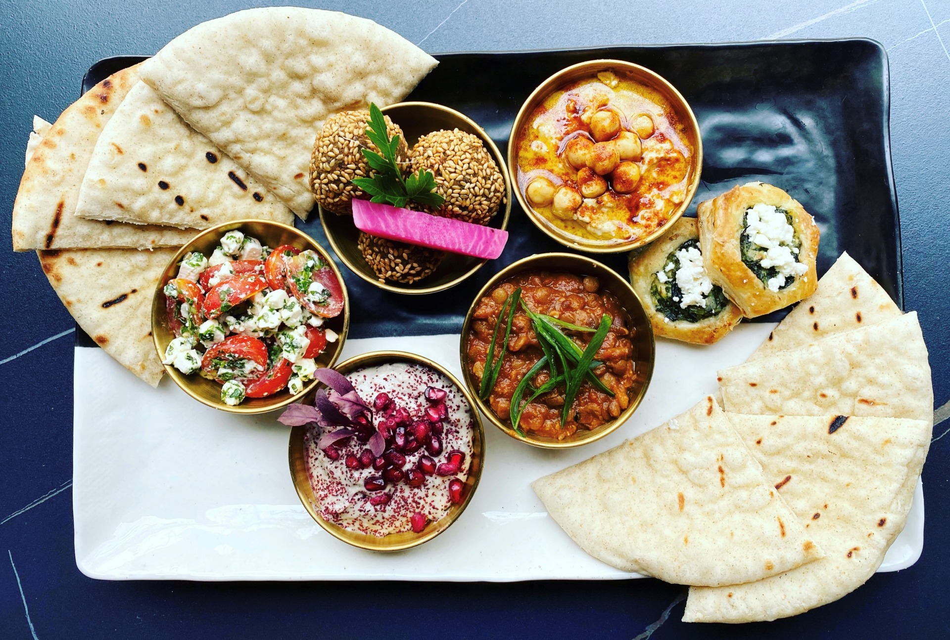 A food platter of Mediterranean-inspired food laid out on a platter.