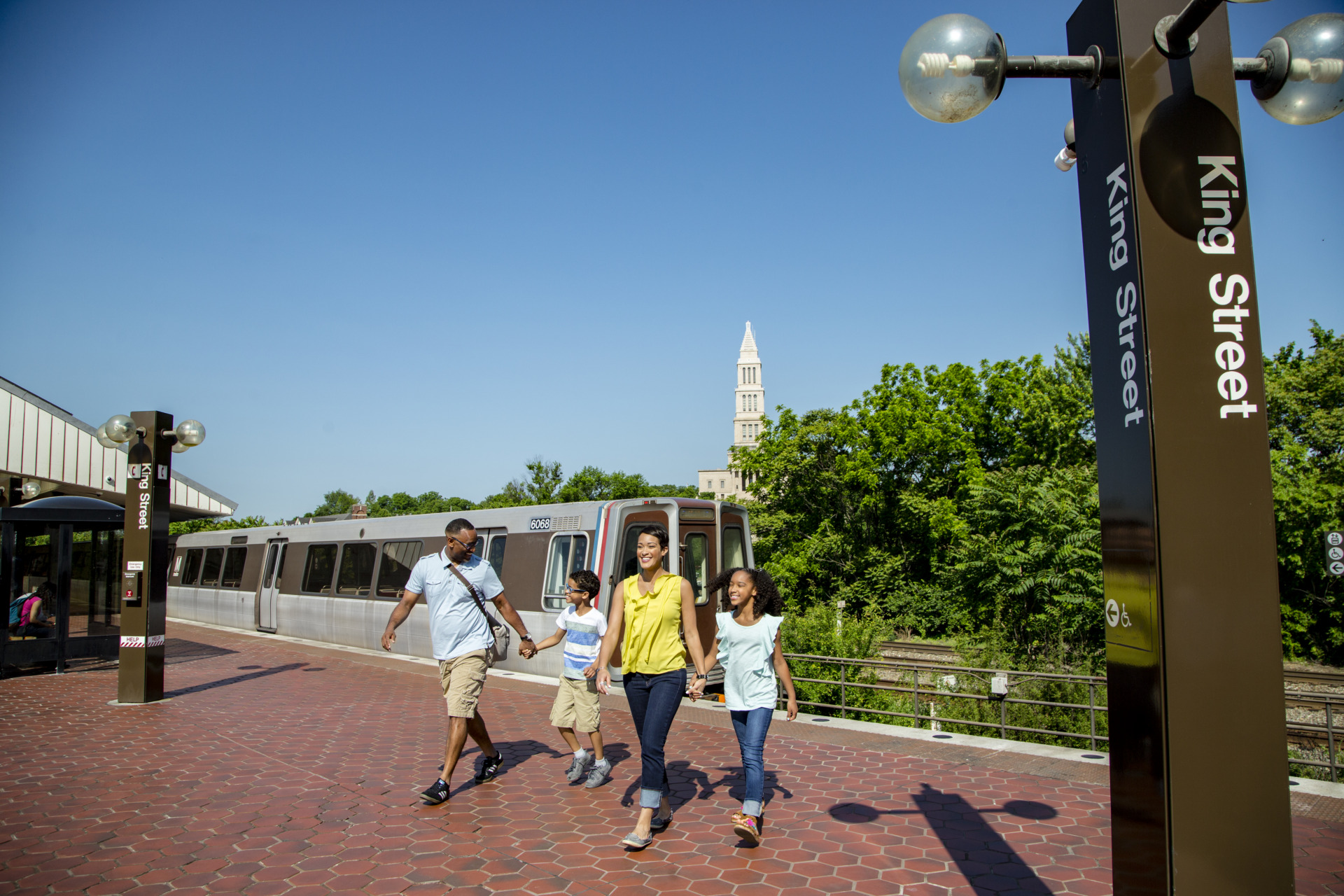 A family of four people stepping onto the King Street metro platform.