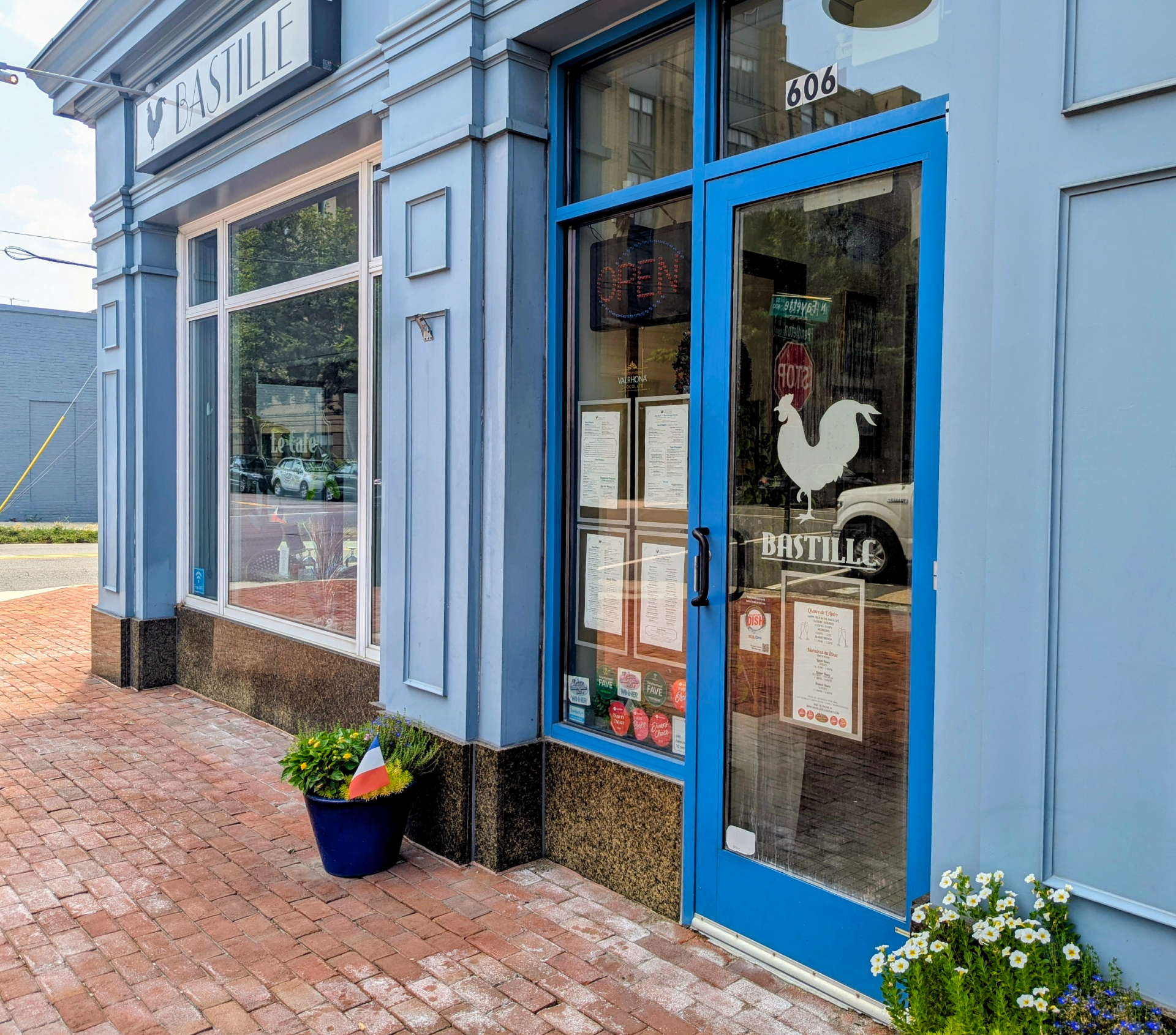 The front entrance of Bastille. The restaurant is painted in blue and an image of a rooter makes up their logo on the front door.