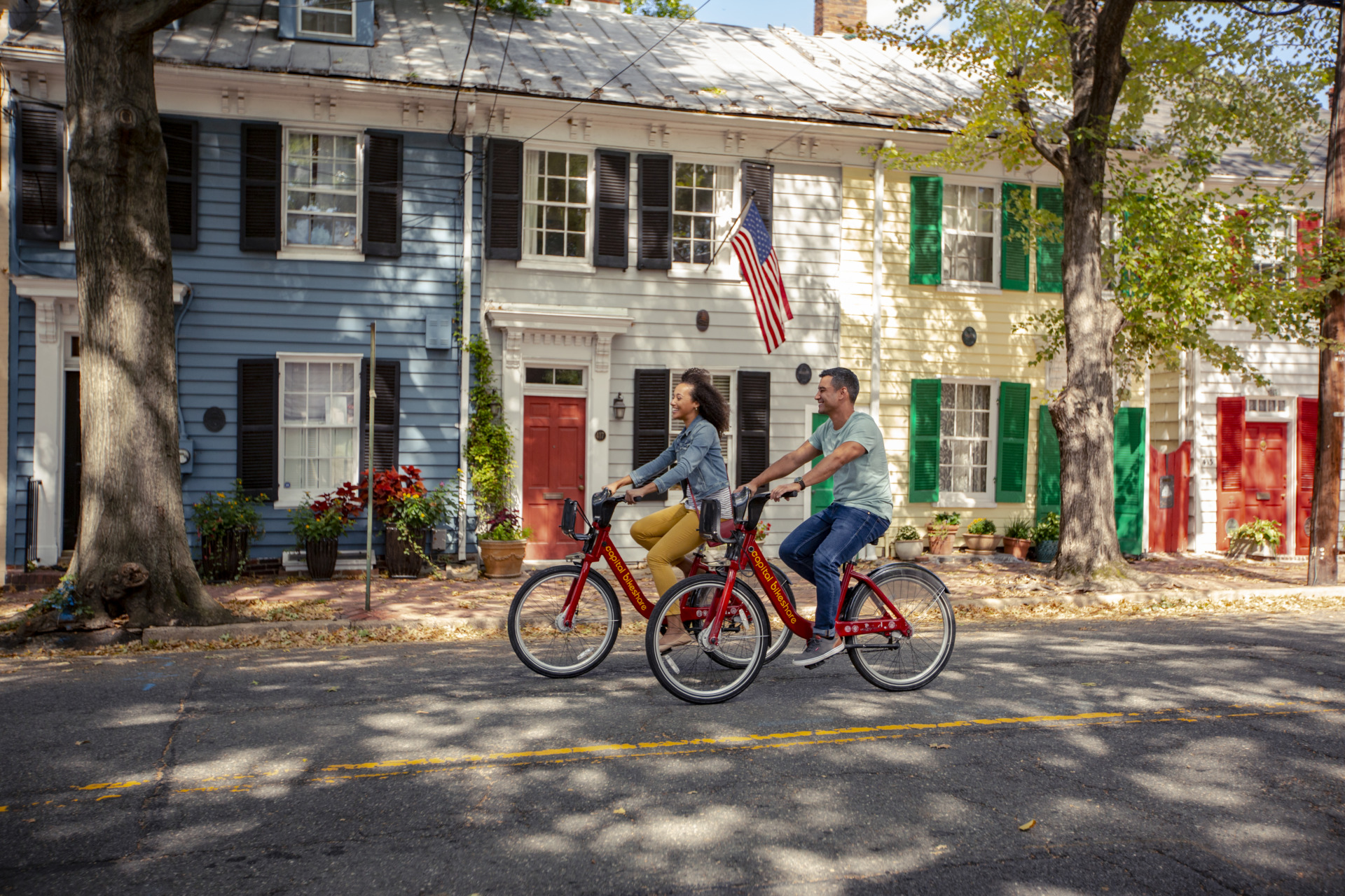 Two people riding bikes along the street in historic Alexandria.