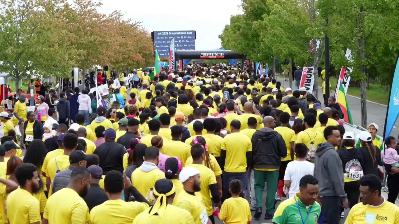 A group of participants at the Grand African Run at the race's starting line and wearing yellow.
