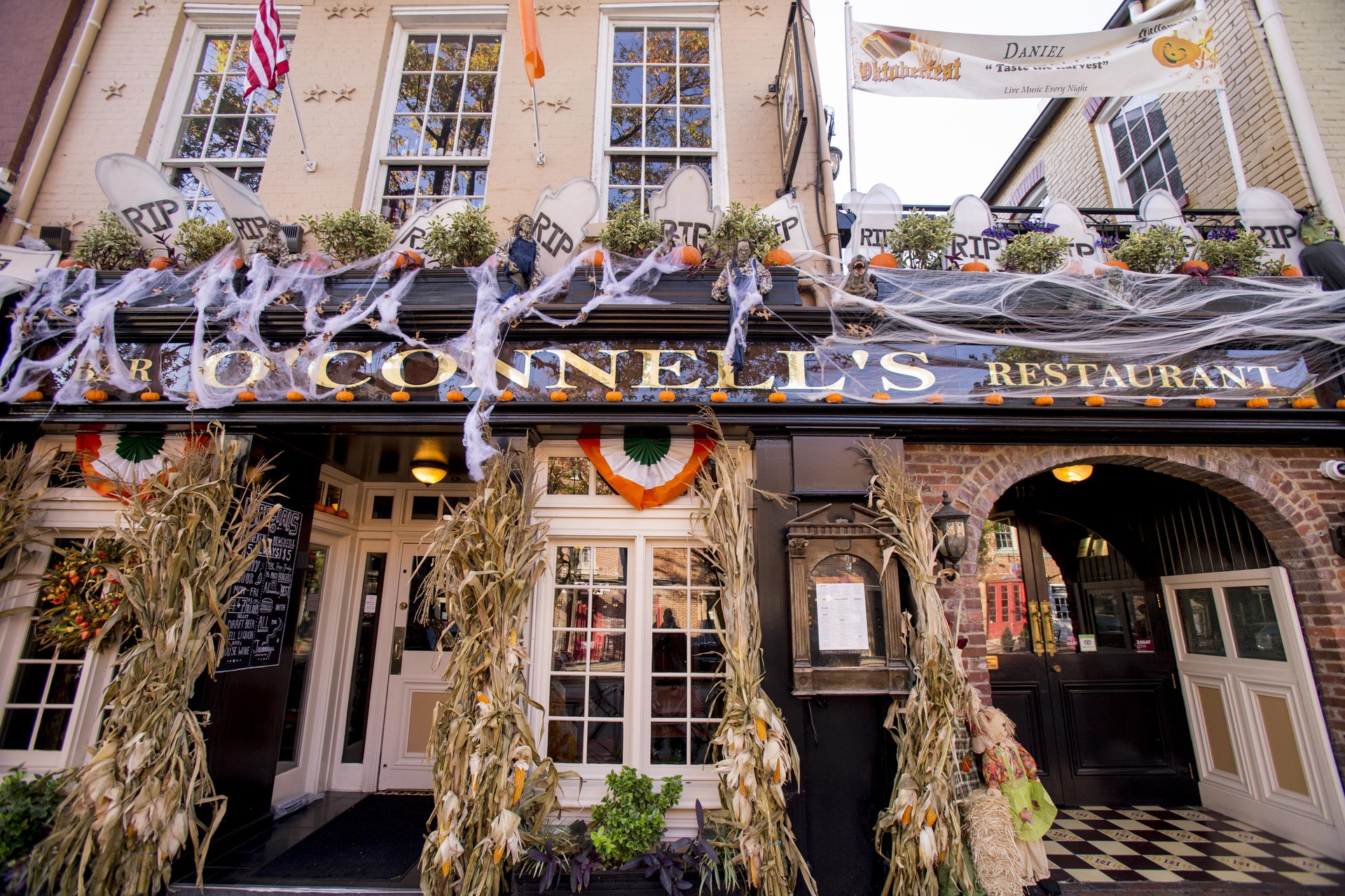 The front of O'Connell's decorated in faux cobwebs, hay, gravestones, and other Halloween decorations. 
