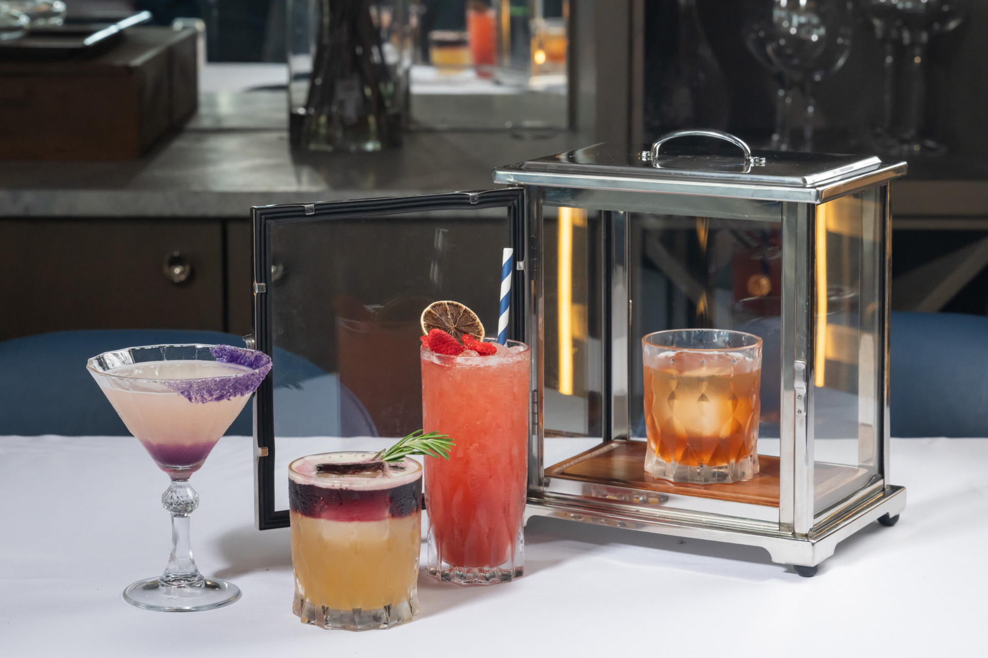 A variety of cocktails and drinks artfully displayed on a white table cloth and dining table at Jula's on the Potomac. 