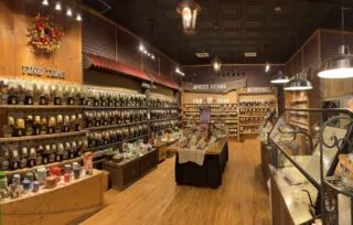 Inside the Spice & Tea Exchange rows of teas, various seasonings including herbs, salts, and spice are neatly displayed in jars and pouches across the room's walls.